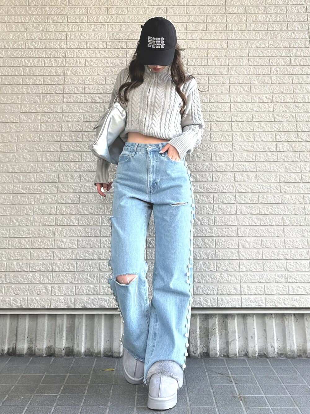 グレー系のニット/セーター、ブルー系のデニムパンツ、グレー系のシューズを着用したレディースの冬コーディネートの2枚目の写真