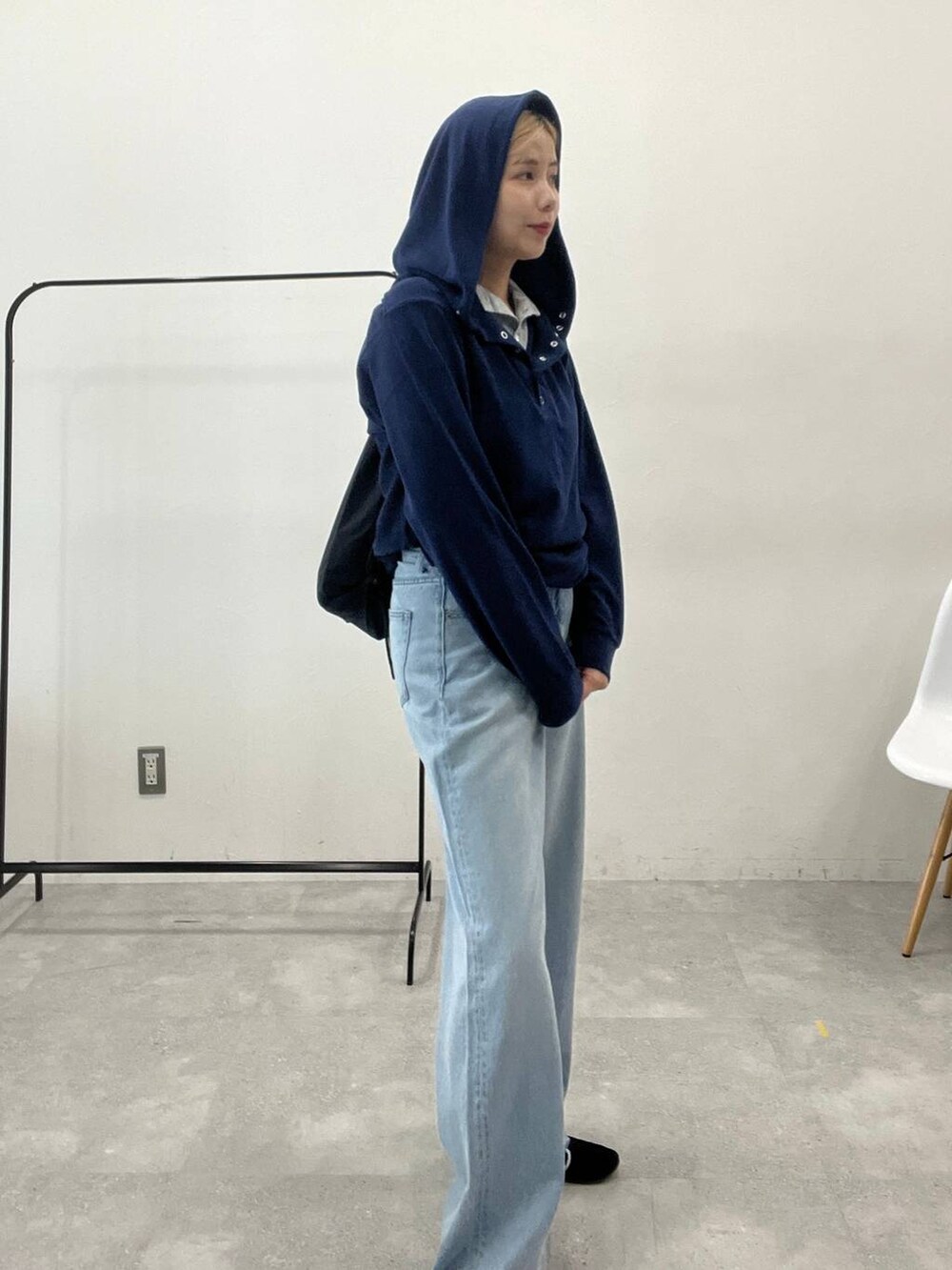 ブルー系のデニムパンツ、ブラック系のバックパック/リュック、ブルー系のパーカーを着用したレディースの秋コーディネートの3枚目の写真