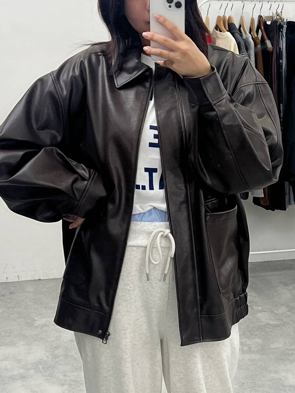 ブラウン系のブルゾン、ブラック系のブーツ、ホワイト系のTシャツ/カットソーを着用したレディースの秋コーディネートの2枚目の写真