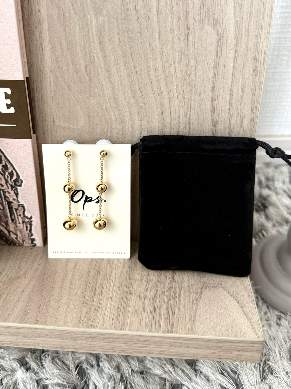 イエロー系のニット/セーター、ゴールド系のピアス（両耳用）を着用したレディースの夏コーディネートの3枚目の写真