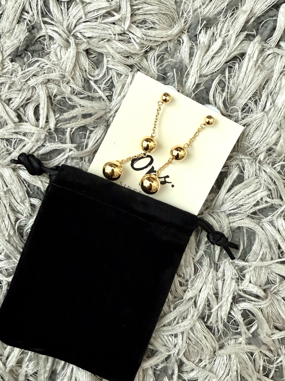 イエロー系のニット/セーター、ゴールド系のピアス（両耳用）を着用したレディースの夏コーディネートの5枚目の写真