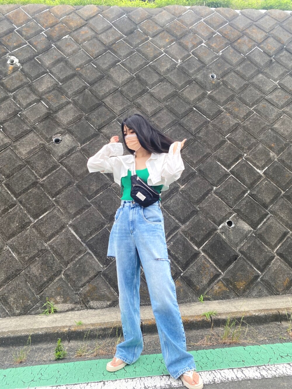 ブルー系のデニムパンツ、ホワイト系のサンダル、グリーン系のニット/セーターを着用したレディースの夏コーディネートの2枚目の写真