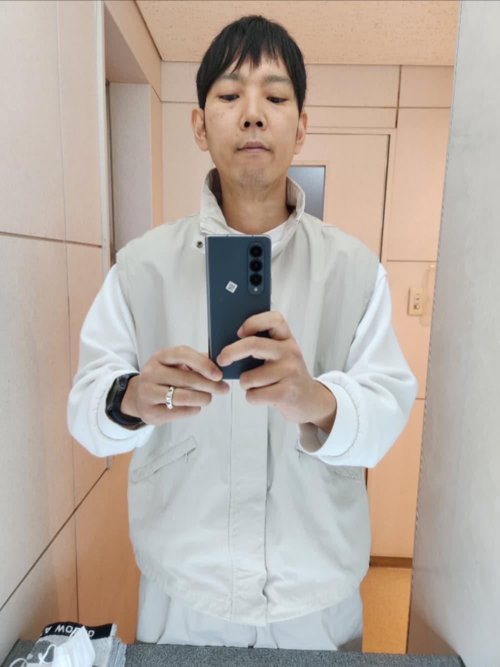 グレー系のブルゾン、ホワイト系のスウェット、グレー系のその他パンツを着用したメンズの秋コーディネートの3枚目の写真