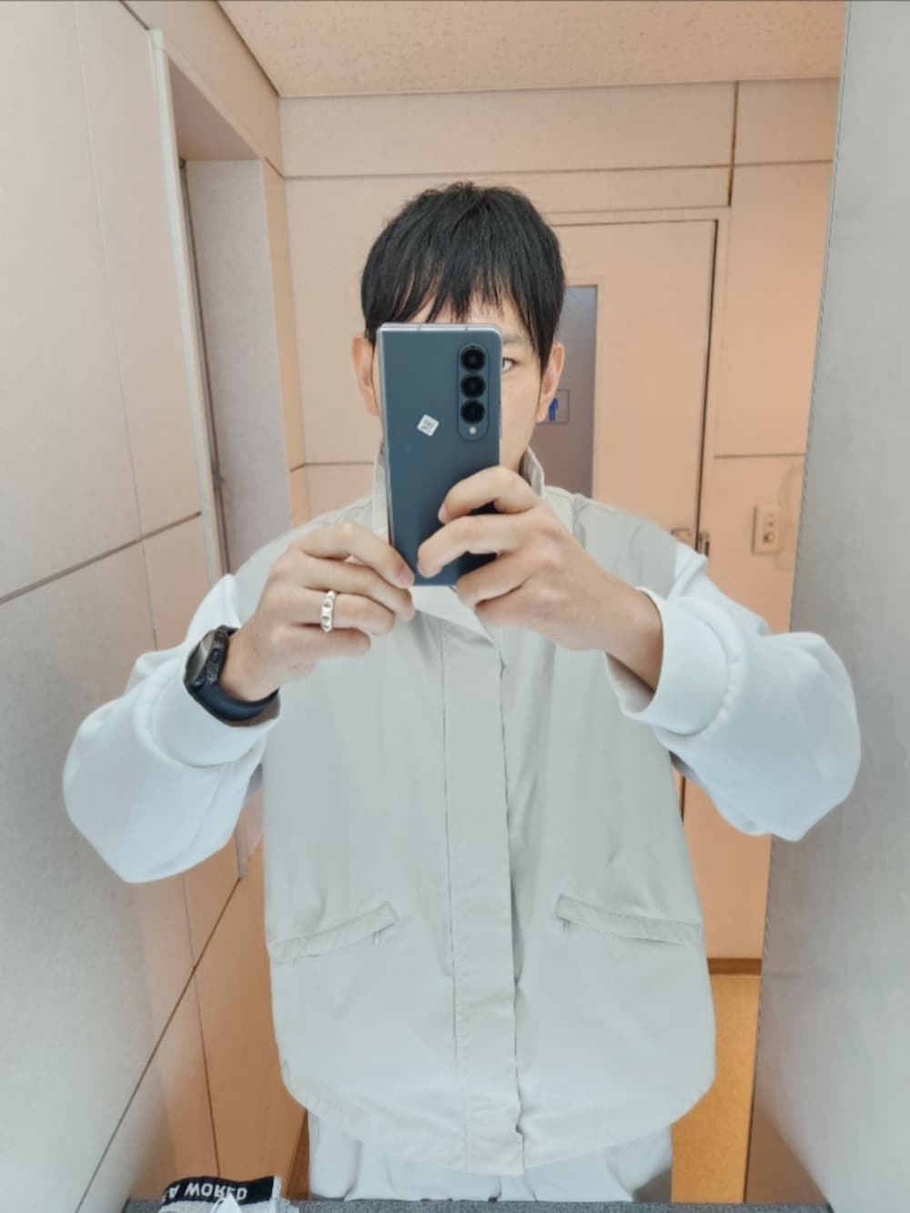 グレー系のブルゾン、ホワイト系のスウェット、グレー系のその他パンツを着用したメンズの秋コーディネートの2枚目の写真