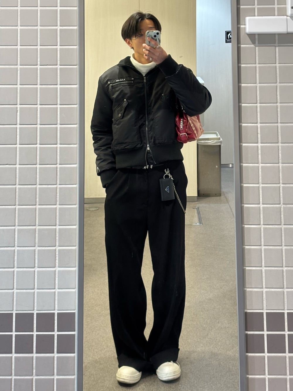 ブラック系のジャケット/アウター、ホワイト系のTシャツ/カットソー、ブラック系のスラックスを着用したメンズの冬コーディネートの3枚目の写真