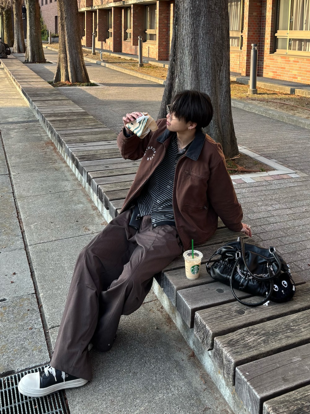 ブラウン系のブルゾン、ブラック系のカーディガン/ボレロ、ブラウン系のスラックスを着用したメンズの冬コーディネートの2枚目の写真