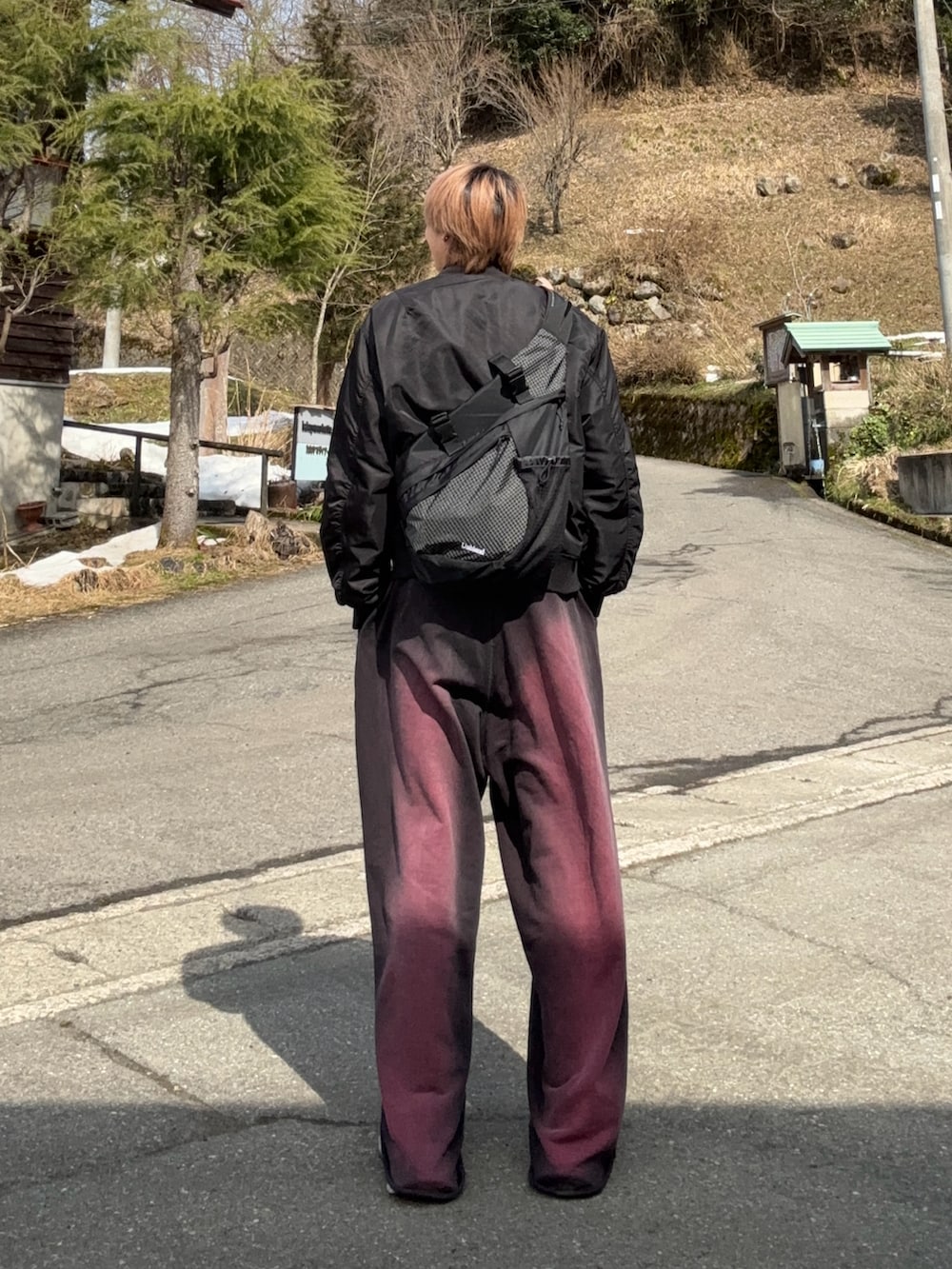 ブラック系のMA-1、レッド系のスウェットパンツ、シルバー系のスニーカーを着用したメンズの春コーディネートの2枚目の写真