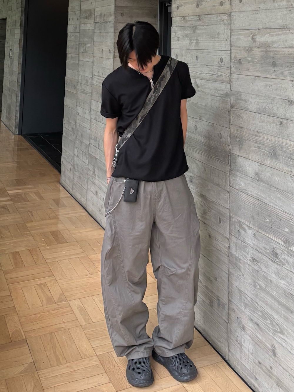 ブラック系のTシャツ/カットソー、グリーン系のショルダーバッグ、グレー系のカーゴパンツを着用したメンズの夏コーディネートの2枚目の写真