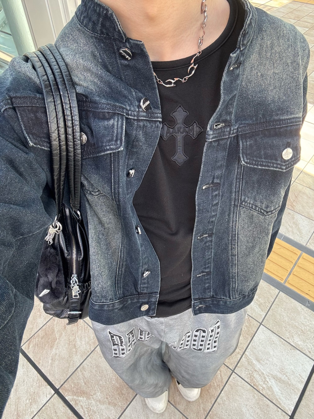 ブルー系のデニムジャケット、その他のTシャツ/カットソー、ブラック系のショルダーバッグを着用したメンズの冬コーディネートの4枚目の写真