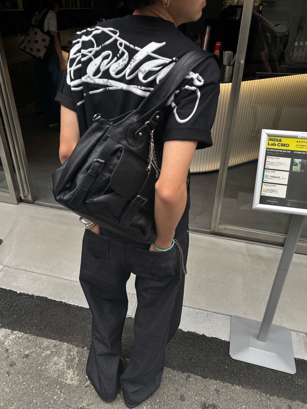 ブラウン系のショルダーバッグ、ブラック系のTシャツ/カットソー、ブラック系のデニムパンツを着用したメンズの夏コーディネートの4枚目の写真