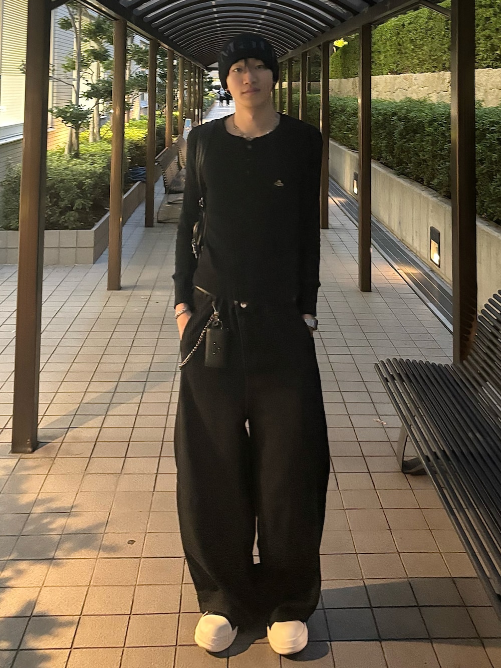 ブラック系のトップス、ブラック系のデニムパンツ、ブラック系のスニーカーを着用したメンズの秋コーディネートの2枚目の写真