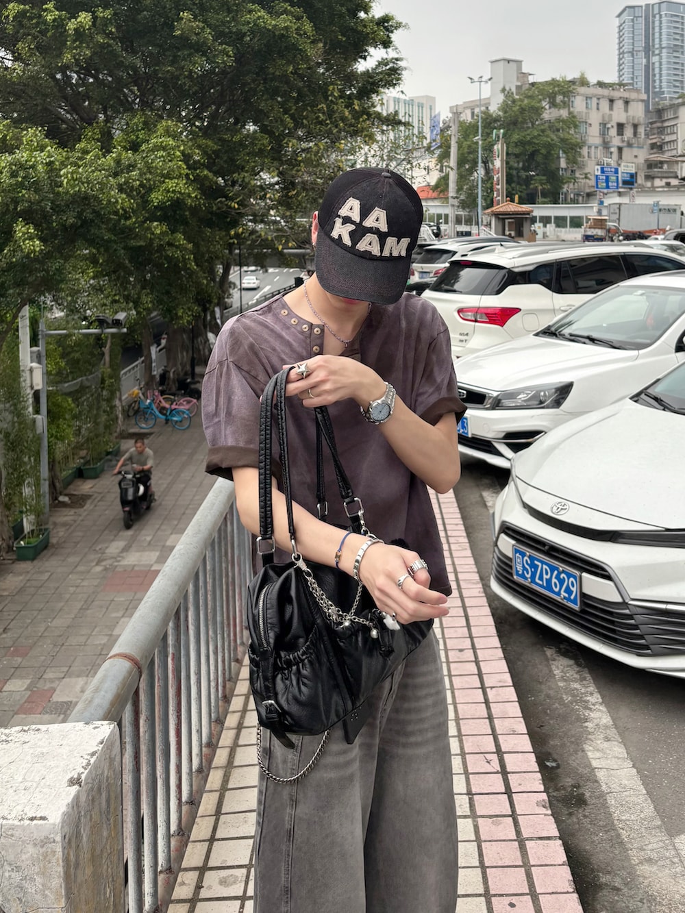 ブラウン系のTシャツ/カットソー、グレー系のデニムパンツ、ブラック系のサンダルを着用したメンズの春コーディネートの4枚目の写真