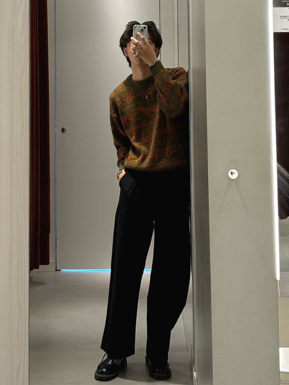 ブルー系のデニムパンツ、ブラック系のシューズ、ブラウン系のニット/セーターを着用したメンズの秋コーディネートの2枚目の写真