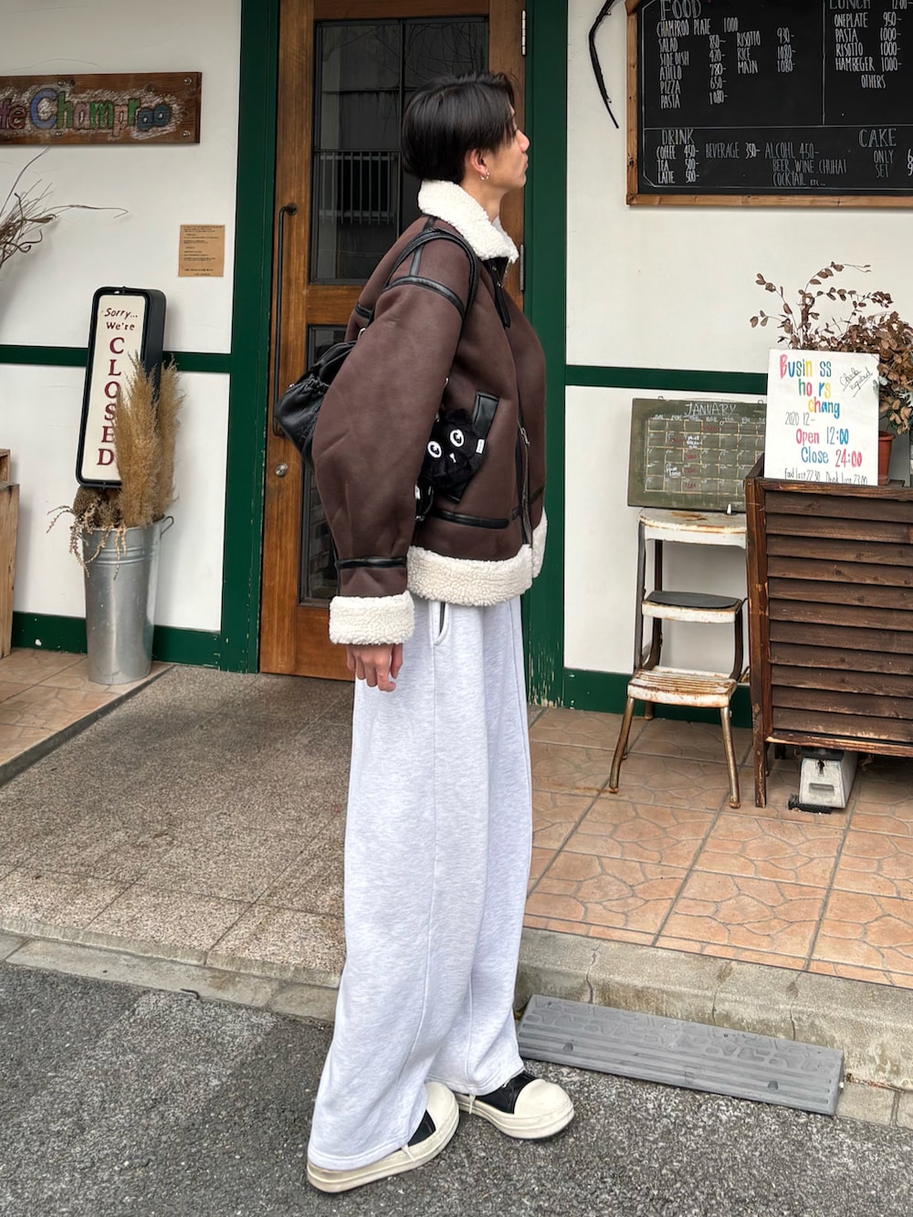 ブラック系のカーディガン/ボレロ、ブラウン系のムートンコート、グレー系のスウェットパンツを着用したメンズの冬コーディネートの2枚目の写真