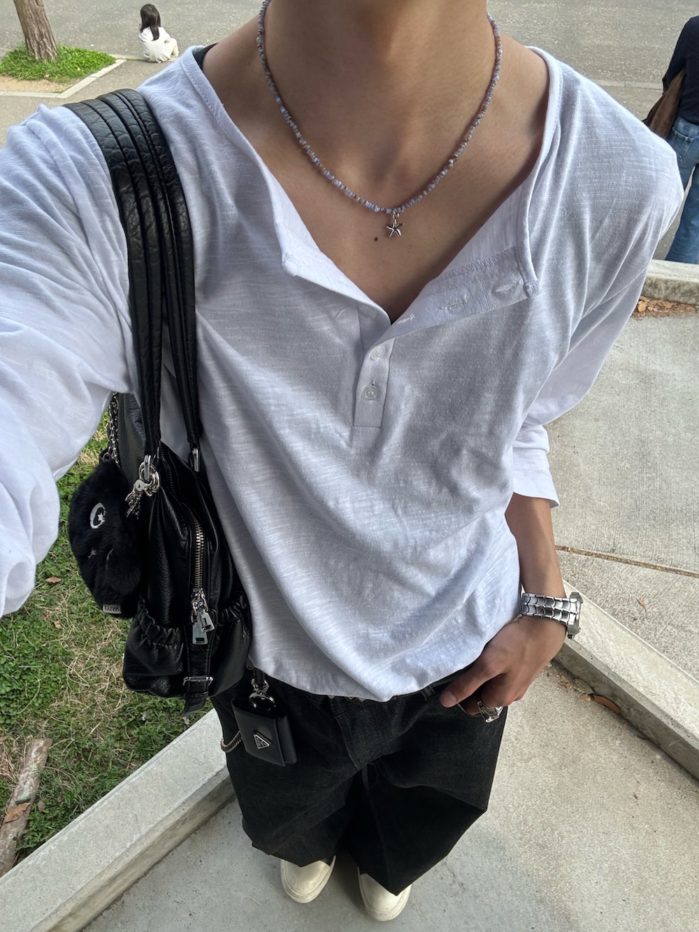 ホワイト系のTシャツ/カットソー、ブラック系のデニムパンツ、ブラック系のスニーカーを着用したメンズの春コーディネートの4枚目の写真