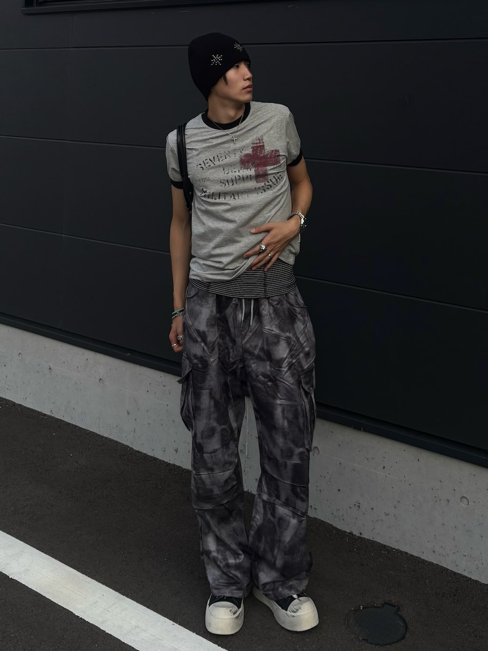 グレー系のTシャツ/カットソー、グレー系のカーゴパンツ、ブラック系のスニーカーを着用したメンズの夏コーディネートの2枚目の写真