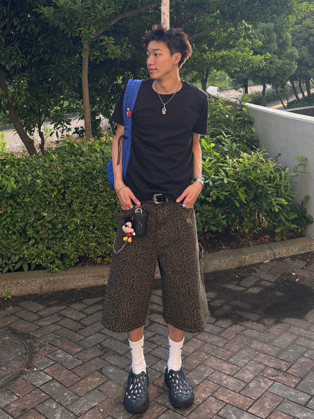 ブラック系のTシャツ/カットソー、ブラウン系のデニムパンツ、ブラック系のサンダルを着用したメンズの夏コーディネートの2枚目の写真