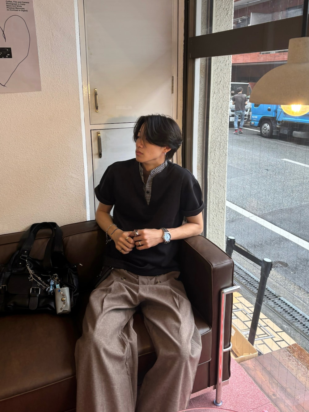 ブラック系のTシャツ/カットソー、ブラウン系のスラックス、ブラック系のスニーカーを着用したメンズの夏コーディネートの4枚目の写真