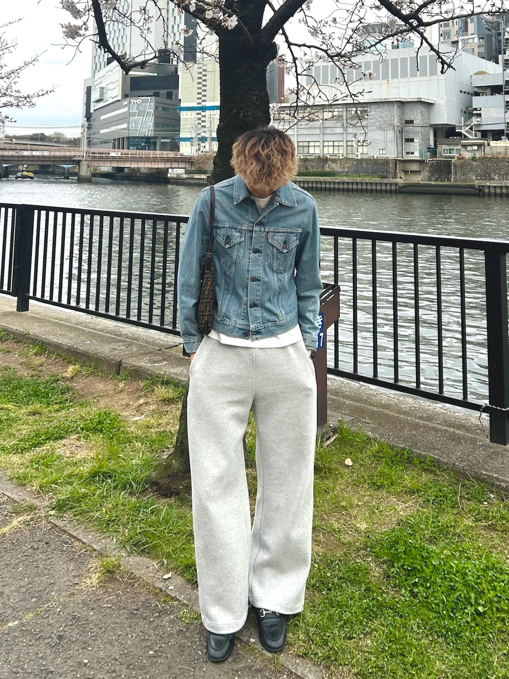 ブルー系のデニムジャケット、グレー系のスウェットパンツ、ブラック系のローファーを着用したメンズの春コーディネートの2枚目の写真