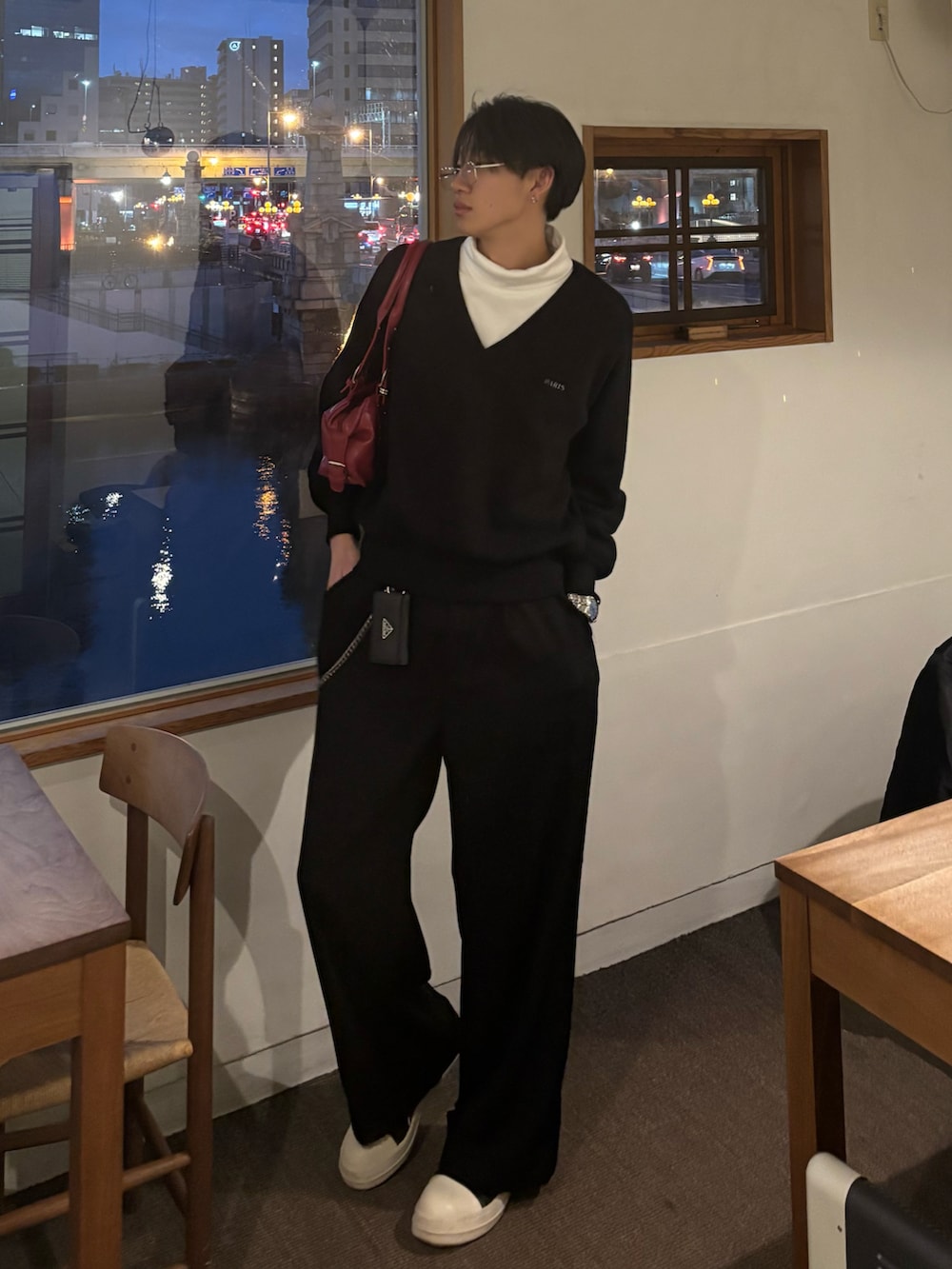 ブラック系のニット/セーター、ホワイト系のTシャツ/カットソー、レッド系のバッグを着用したメンズの冬コーディネートの2枚目の写真