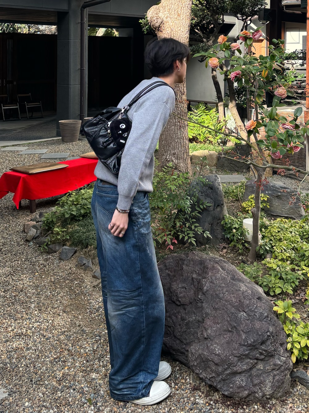 グレー系のカーディガン/ボレロ、ホワイト系のTシャツ/カットソー、ブルー系のデニムパンツを着用したメンズの春コーディネートの4枚目の写真