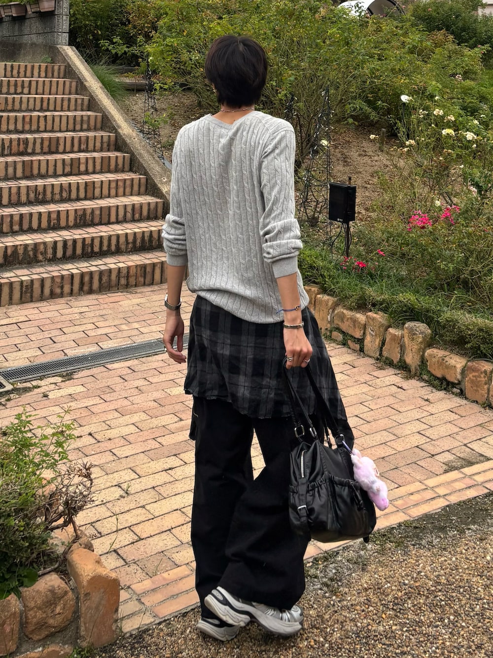 ホワイト系のスニーカー、ブラック系のシャツ/ブラウス、グレー系のニット/セーターを着用したメンズの秋コーディネートの3枚目の写真