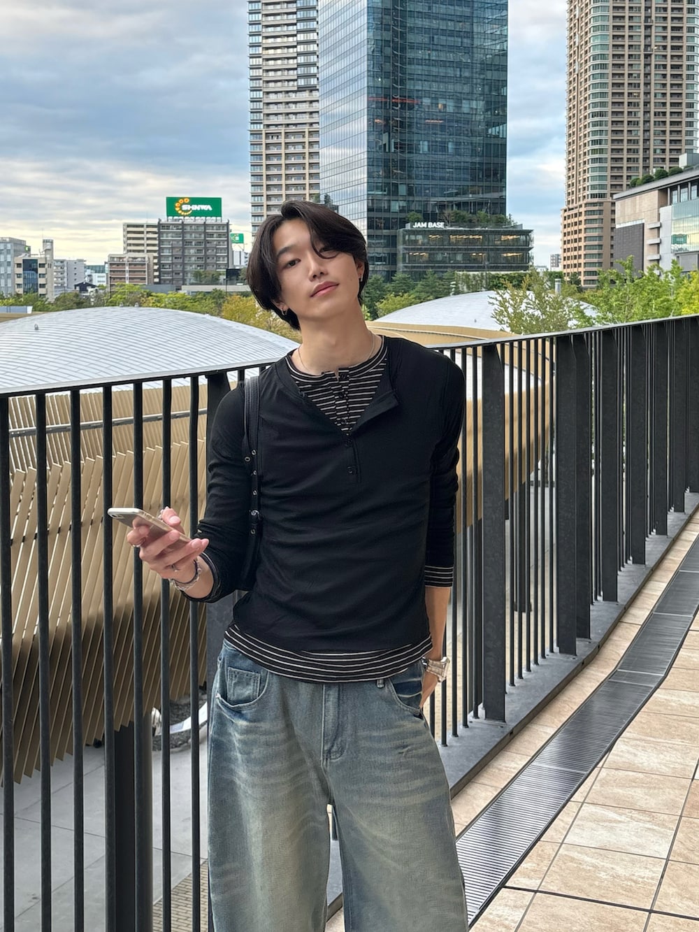 ブラック系のTシャツ/カットソー、ブルー系のデニムパンツ、ブラック系のスニーカーを着用したメンズの秋コーディネートの3枚目の写真