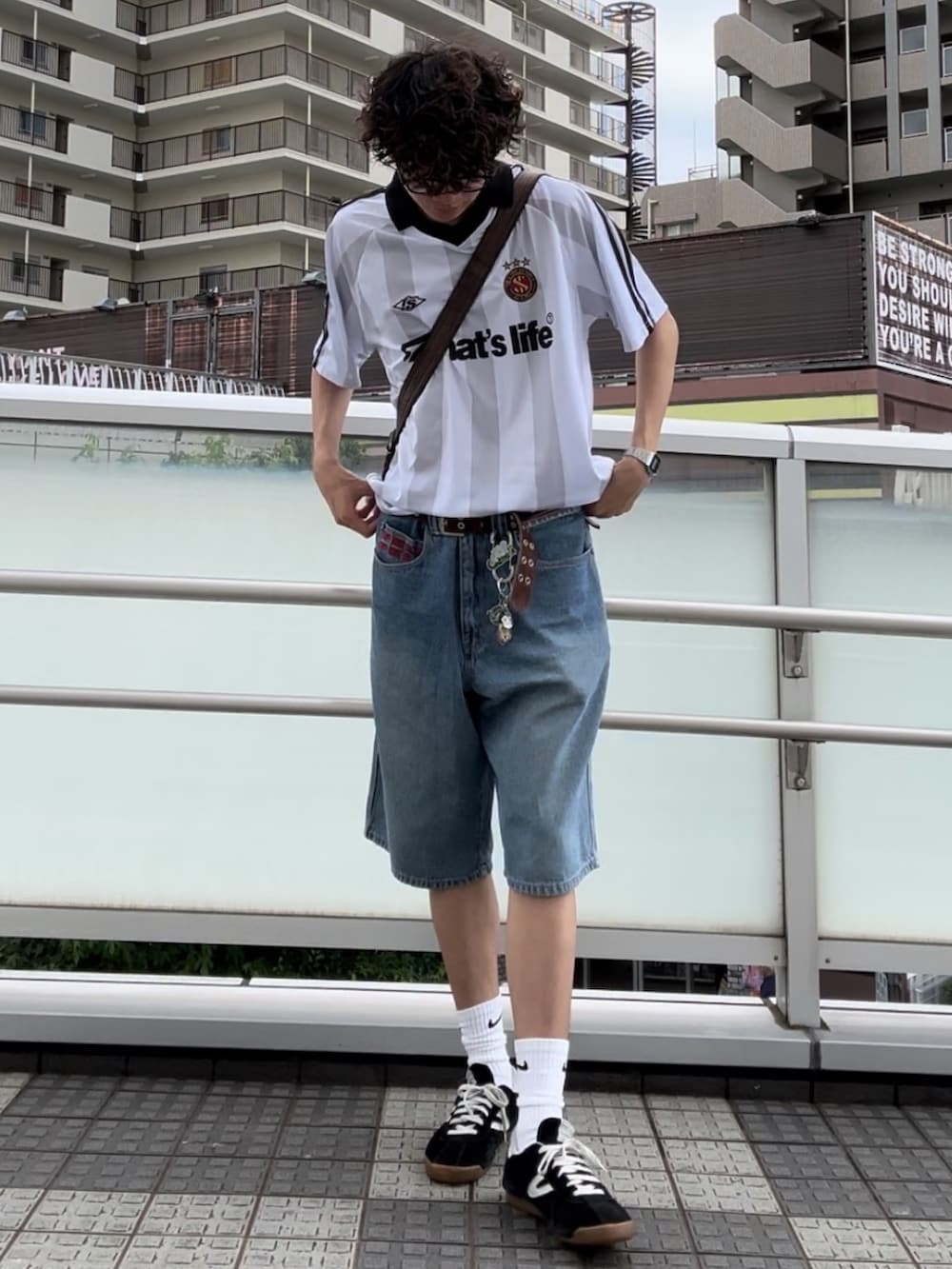 ホワイト系のTシャツ/カットソー、ブルー系のデニムパンツ、ブラック系のスニーカーを着用したメンズの夏コーディネートの2枚目の写真