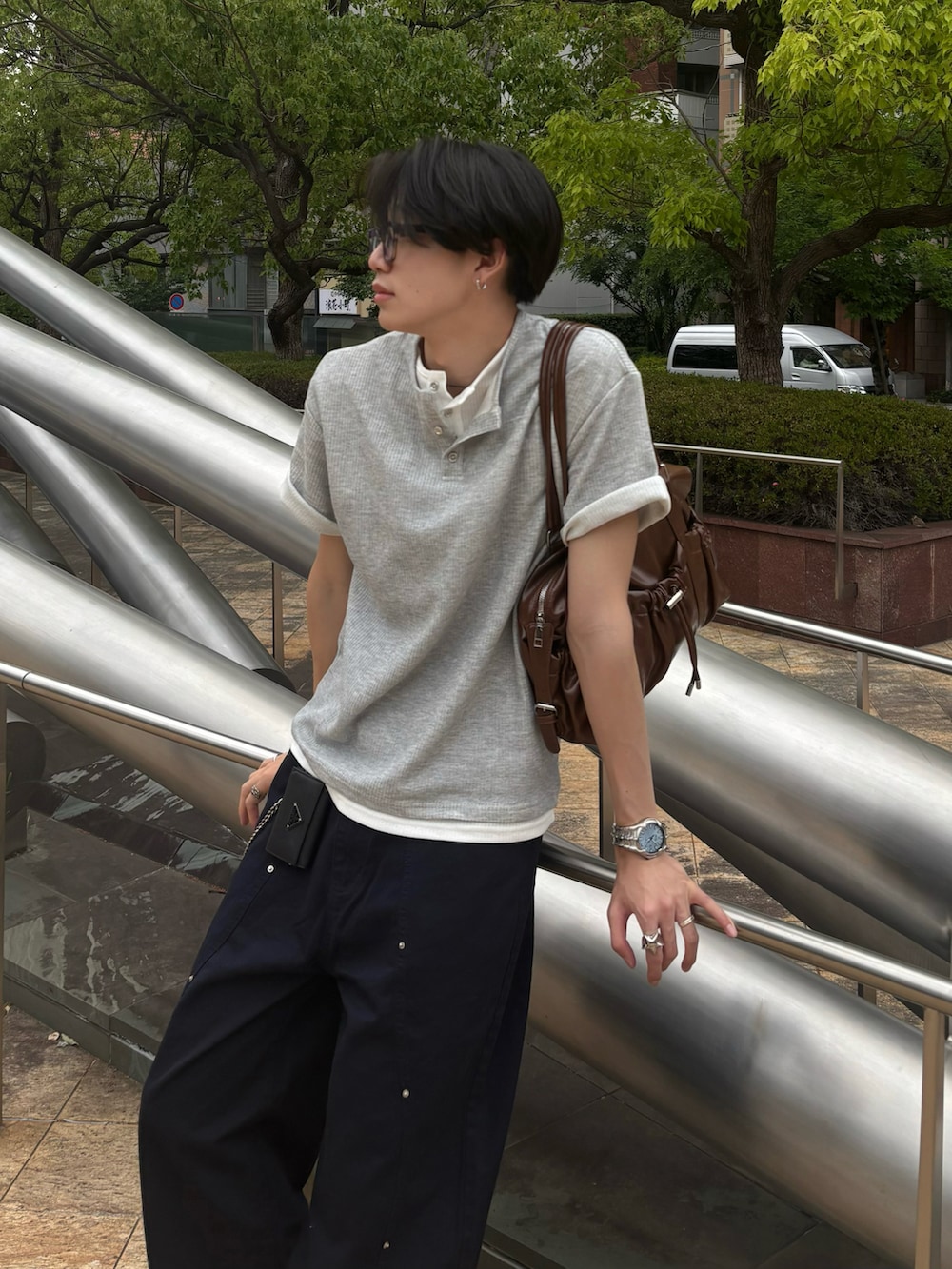 グレー系のTシャツ/カットソー、ブラウン系のショルダーバッグ、ブルー系のチノパンツを着用したメンズの春コーディネートの3枚目の写真