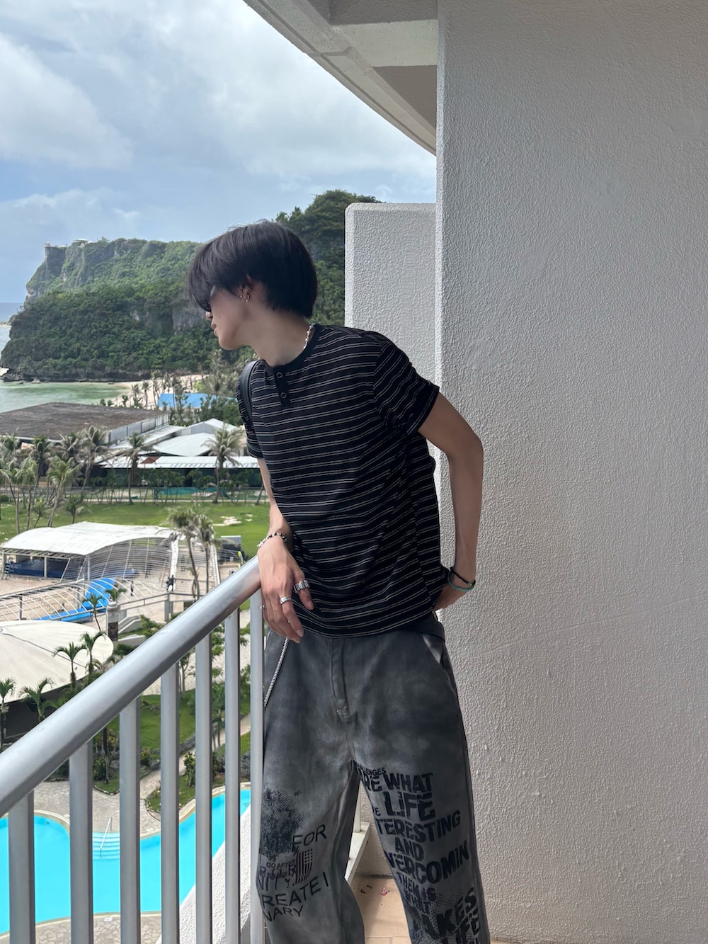 ブラック系のTシャツ/カットソー、ホワイト系のデニムパンツ、ブラック系のサンダルを着用したメンズの夏コーディネートの3枚目の写真