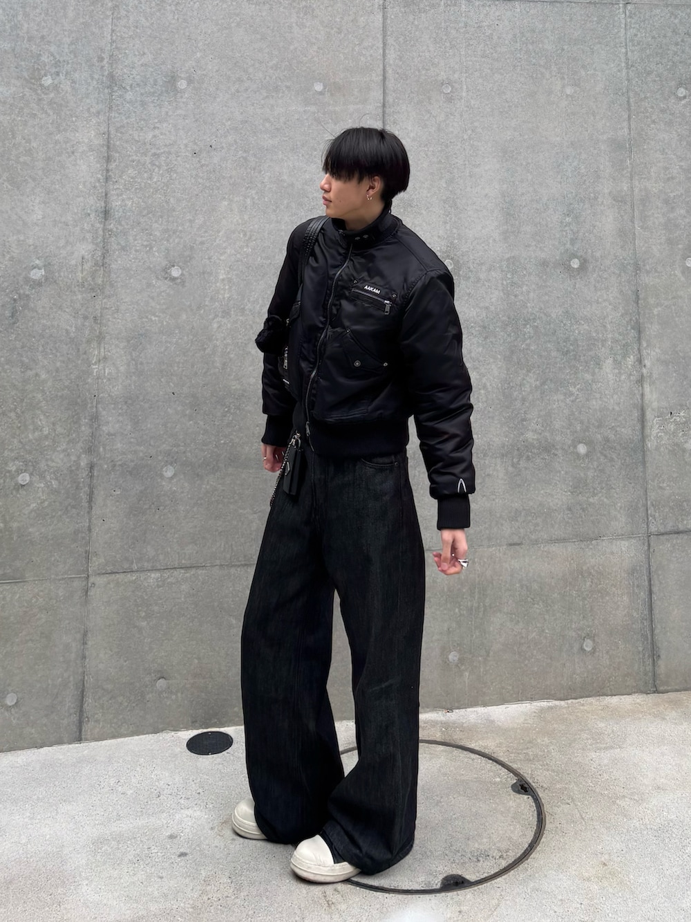 ブラック系のジャケット/アウター、ブラック系のデニムパンツ、ブラック系のスニーカーを着用したメンズの冬コーディネートの2枚目の写真