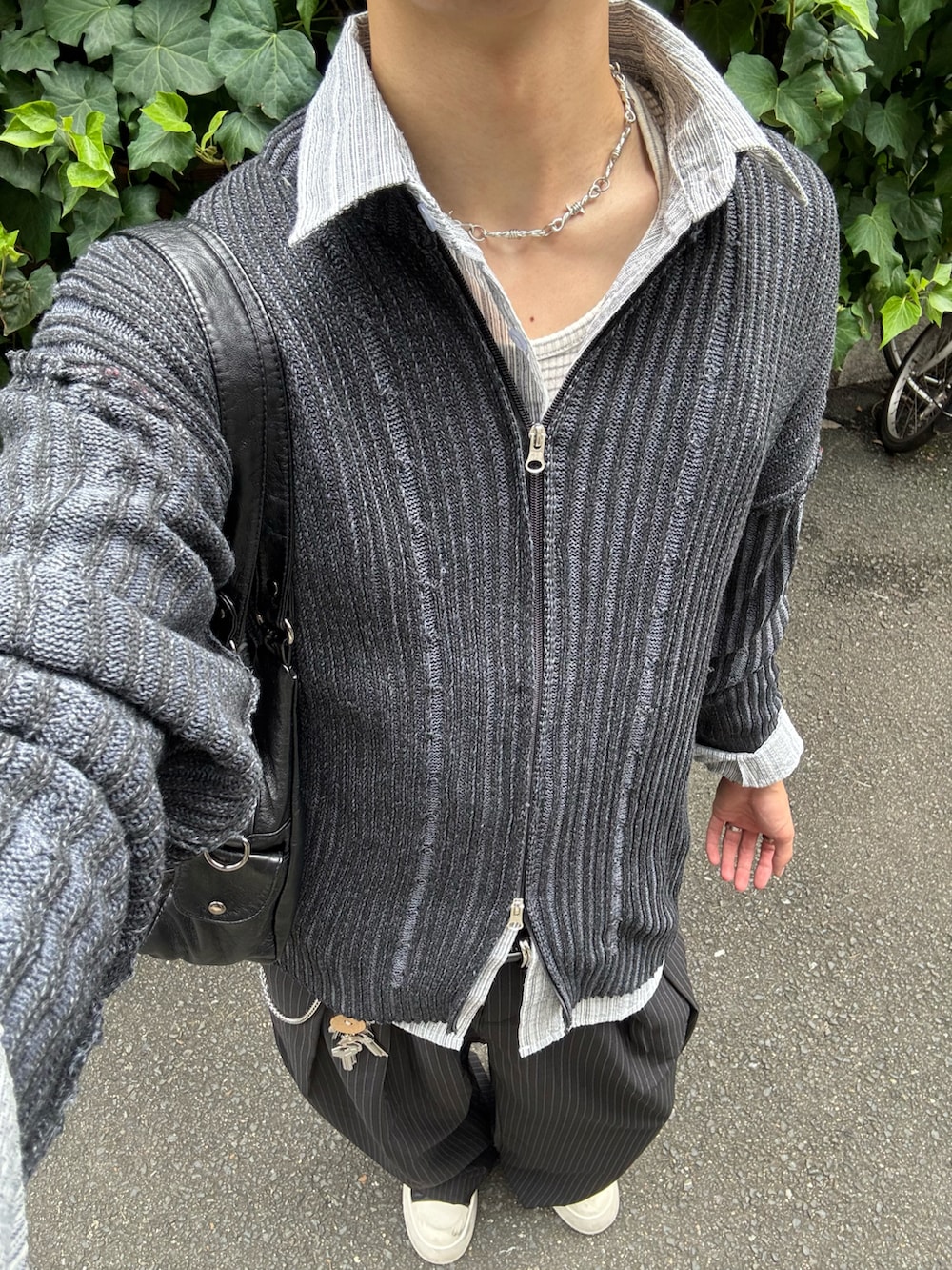 ブラック系のカーディガン/ボレロ、ブラック系のスラックス、ブラック系のスニーカーを着用したメンズの秋コーディネートの5枚目の写真