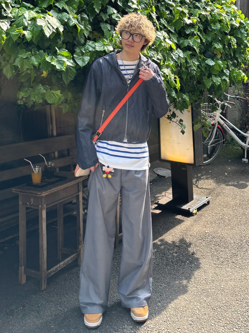 ベージュ系のスニーカー、グレー系のスラックス、ブルー系のTシャツ/カットソーを着用したメンズの春コーディネートの2枚目の写真