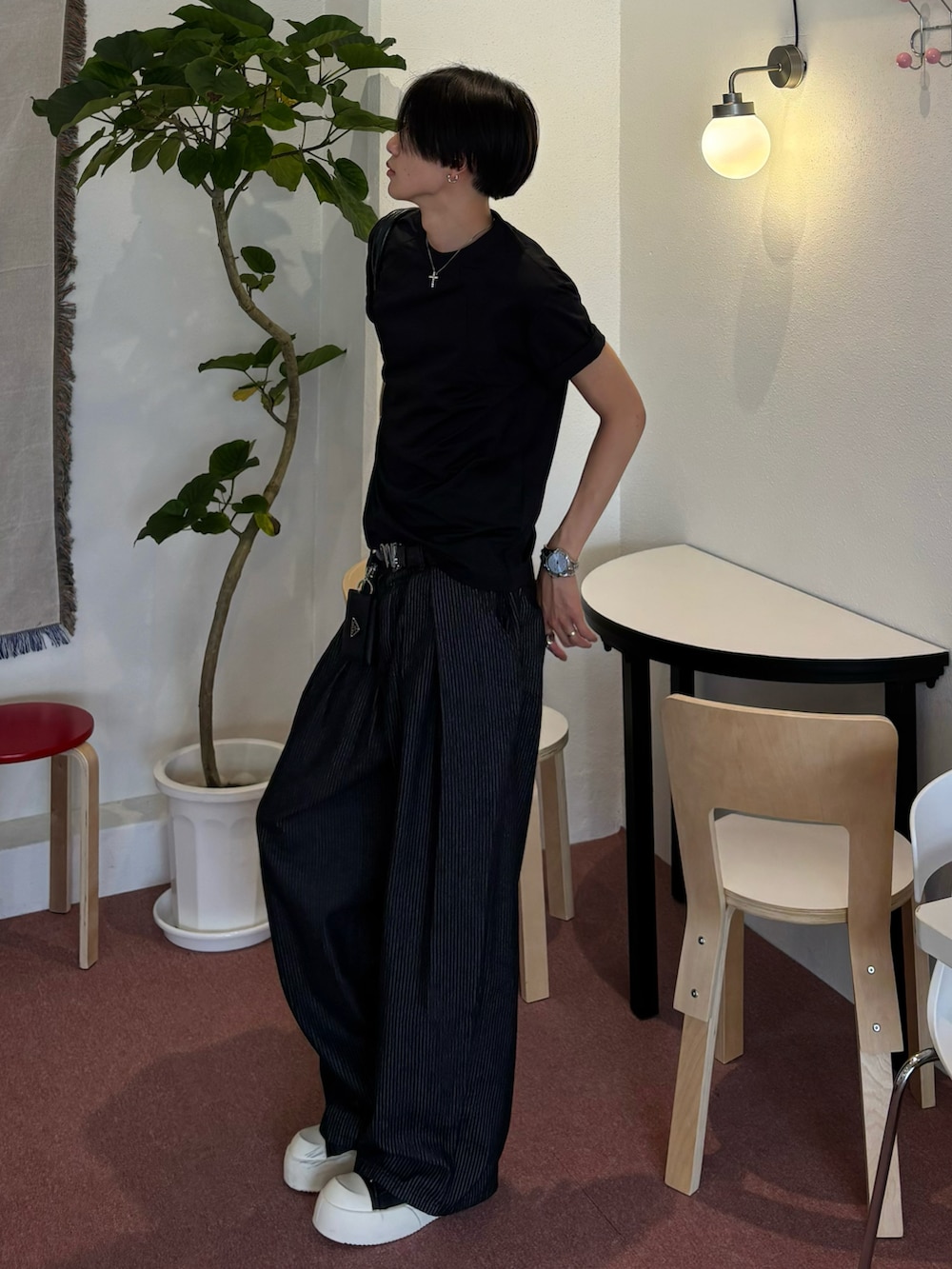 ブラック系のTシャツ/カットソー、ブラック系のスニーカー、ブルー系のデニムパンツを着用したメンズの夏コーディネートの2枚目の写真