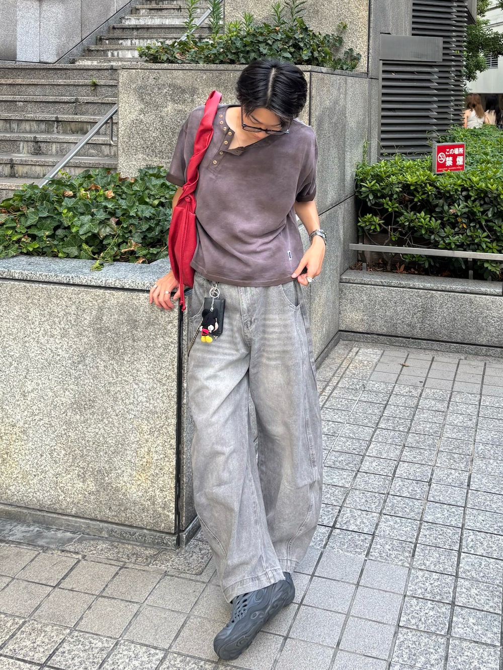 ブラウン系のTシャツ/カットソー、グレー系のデニムパンツ、ブラック系のサンダルを着用したメンズの夏コーディネートの3枚目の写真