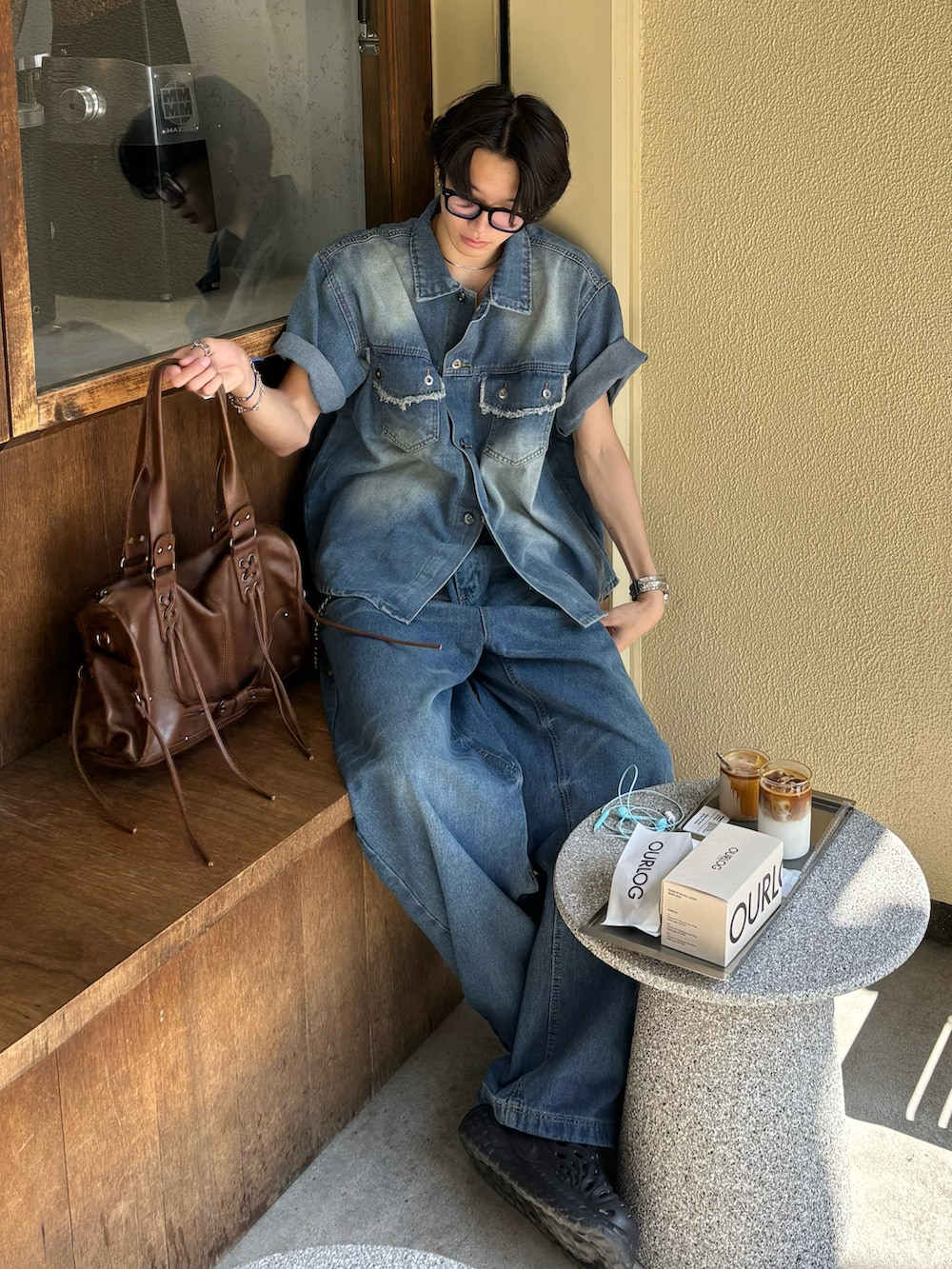 ブルー系のシャツ/ブラウス、ブルー系のデニムパンツ、ブラウン系のショルダーバッグを着用したメンズの春コーディネートの2枚目の写真