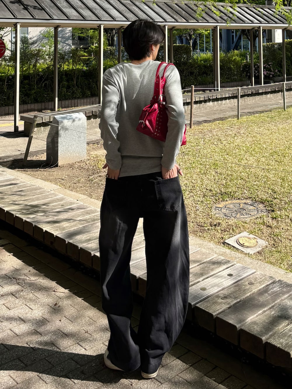 グレー系のTシャツ/カットソー、ブラック系のデニムパンツ、ブラック系のスニーカーを着用したメンズの春コーディネートの5枚目の写真