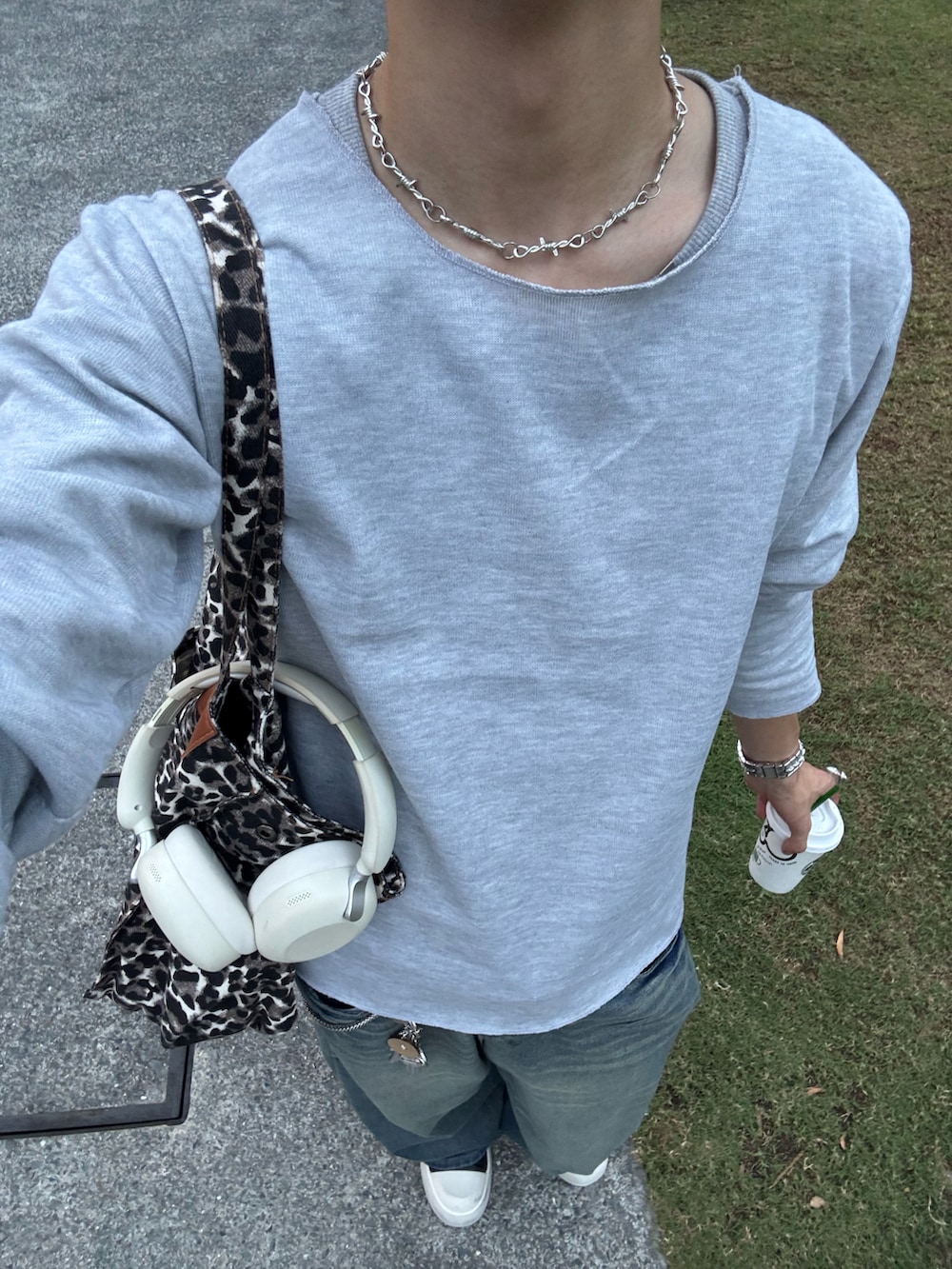 グレー系のTシャツ/カットソー、ブルー系のデニムパンツ、ブラック系のスニーカーを着用したメンズの秋コーディネートの5枚目の写真