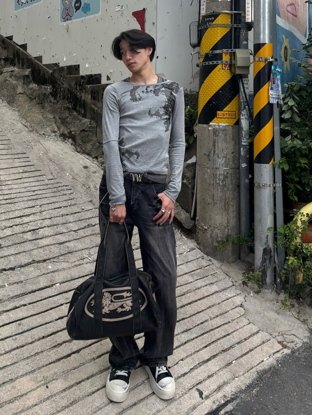 グレー系のTシャツ/カットソー、ブラック系のボストンバッグ、ブラック系のスニーカーを着用したメンズの夏コーディネートの2枚目の写真