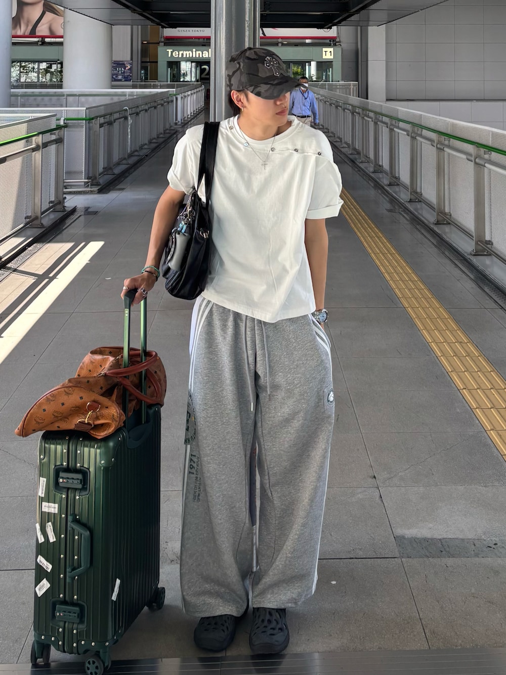 ホワイト系のTシャツ/カットソー、グレー系のスウェットパンツ、ブラック系のサンダルを着用したメンズの夏コーディネートの3枚目の写真