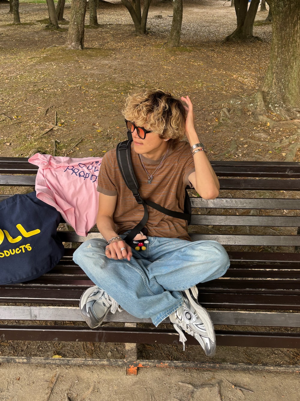 ブラウン系のTシャツ/カットソー、ブルー系のデニムパンツ、ホワイト系のスニーカーを着用したメンズの春コーディネートの2枚目の写真