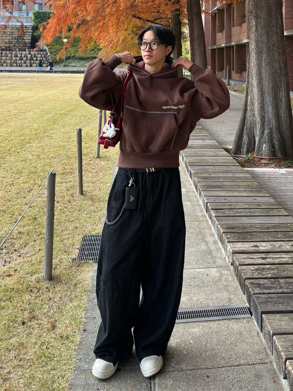 ブラック系のデニムパンツ、ブラック系のスニーカー、ブラウン系のパーカーを着用したメンズの秋コーディネートの3枚目の写真