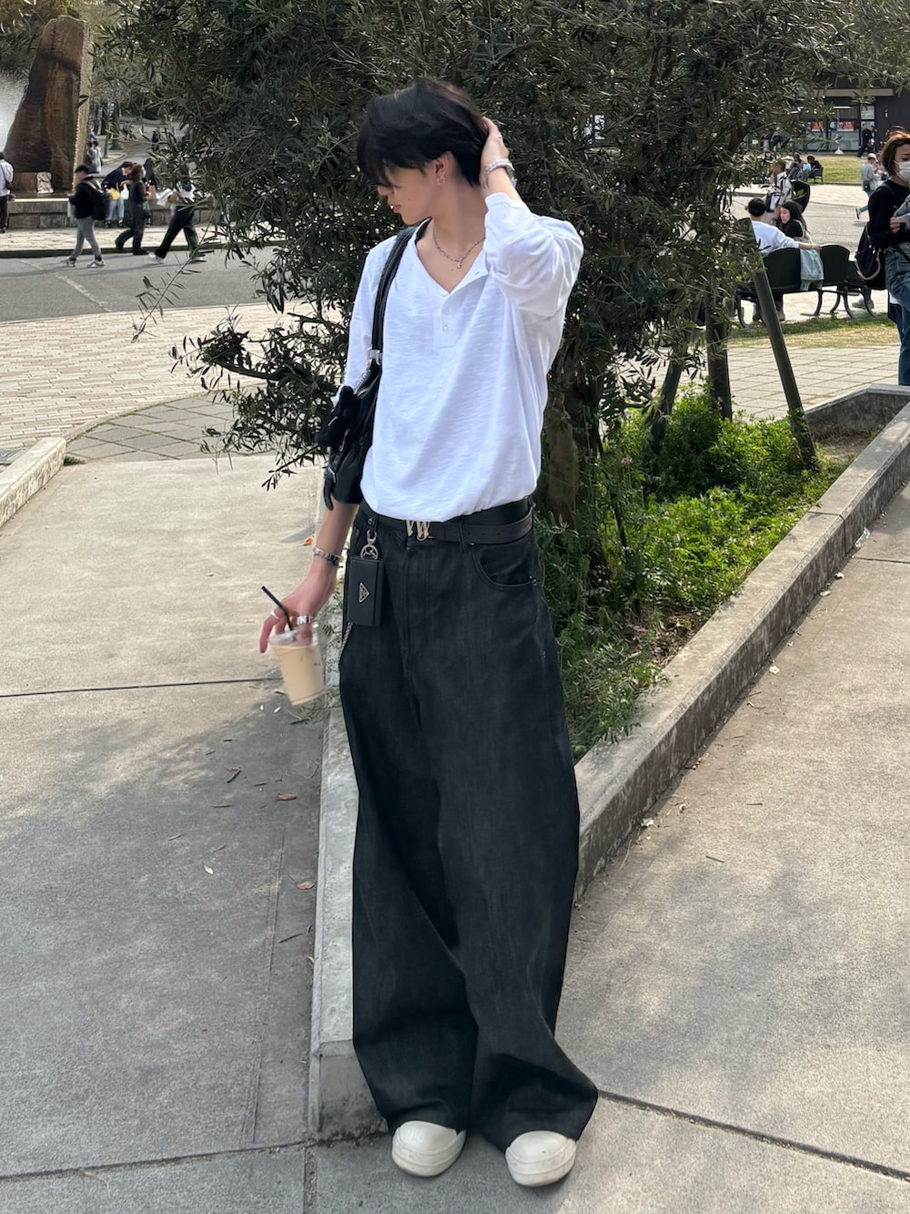 ホワイト系のTシャツ/カットソー、ブラック系のデニムパンツ、ブラック系のスニーカーを着用したメンズの春コーディネートの2枚目の写真