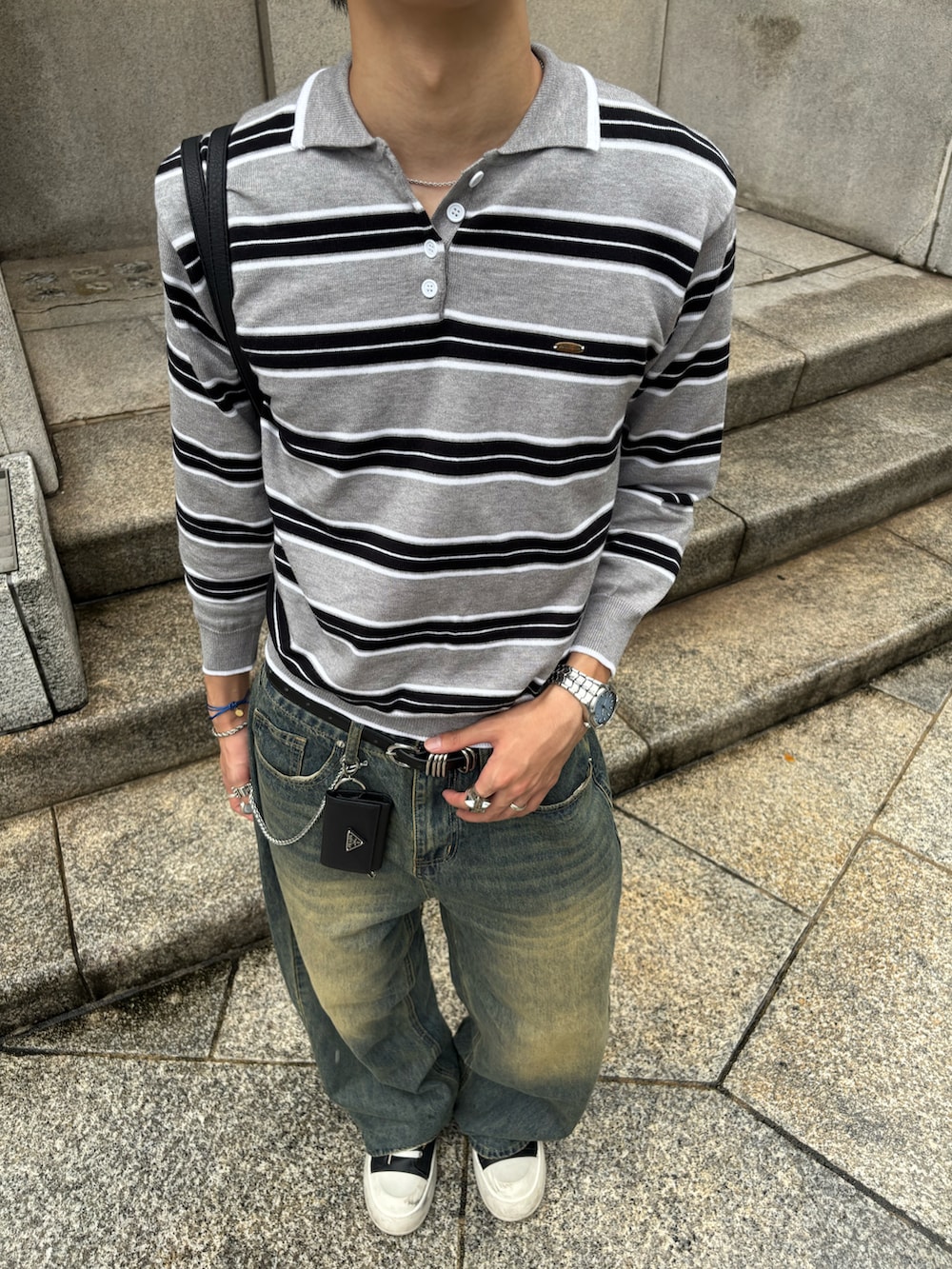 グレー系のニット/セーター、ブルー系のデニムパンツ、ブラック系のスニーカーを着用したメンズの秋コーディネートの5枚目の写真