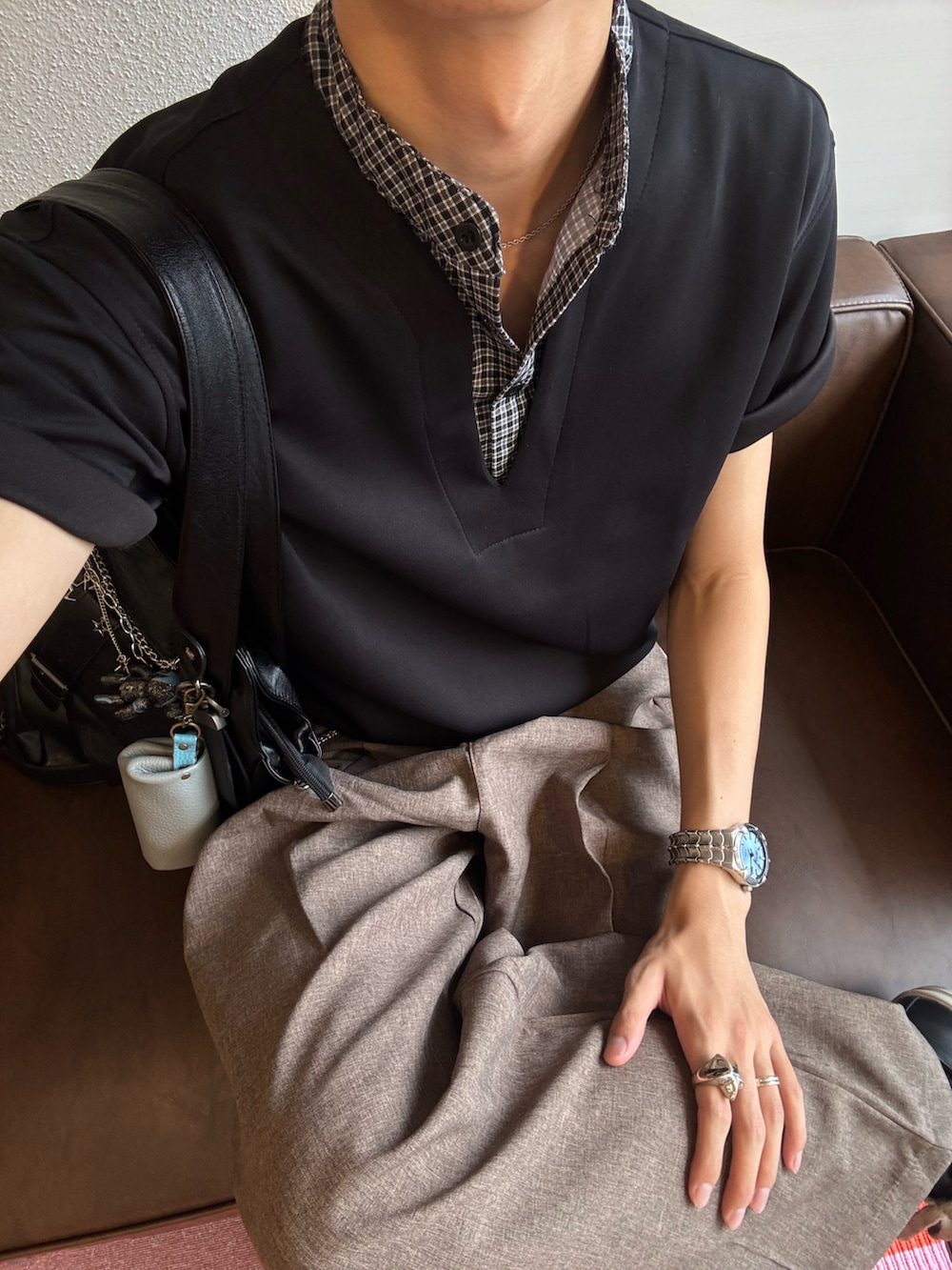 ブラック系のTシャツ/カットソー、ブラウン系のスラックス、ブラック系のスニーカーを着用したメンズの夏コーディネートの5枚目の写真