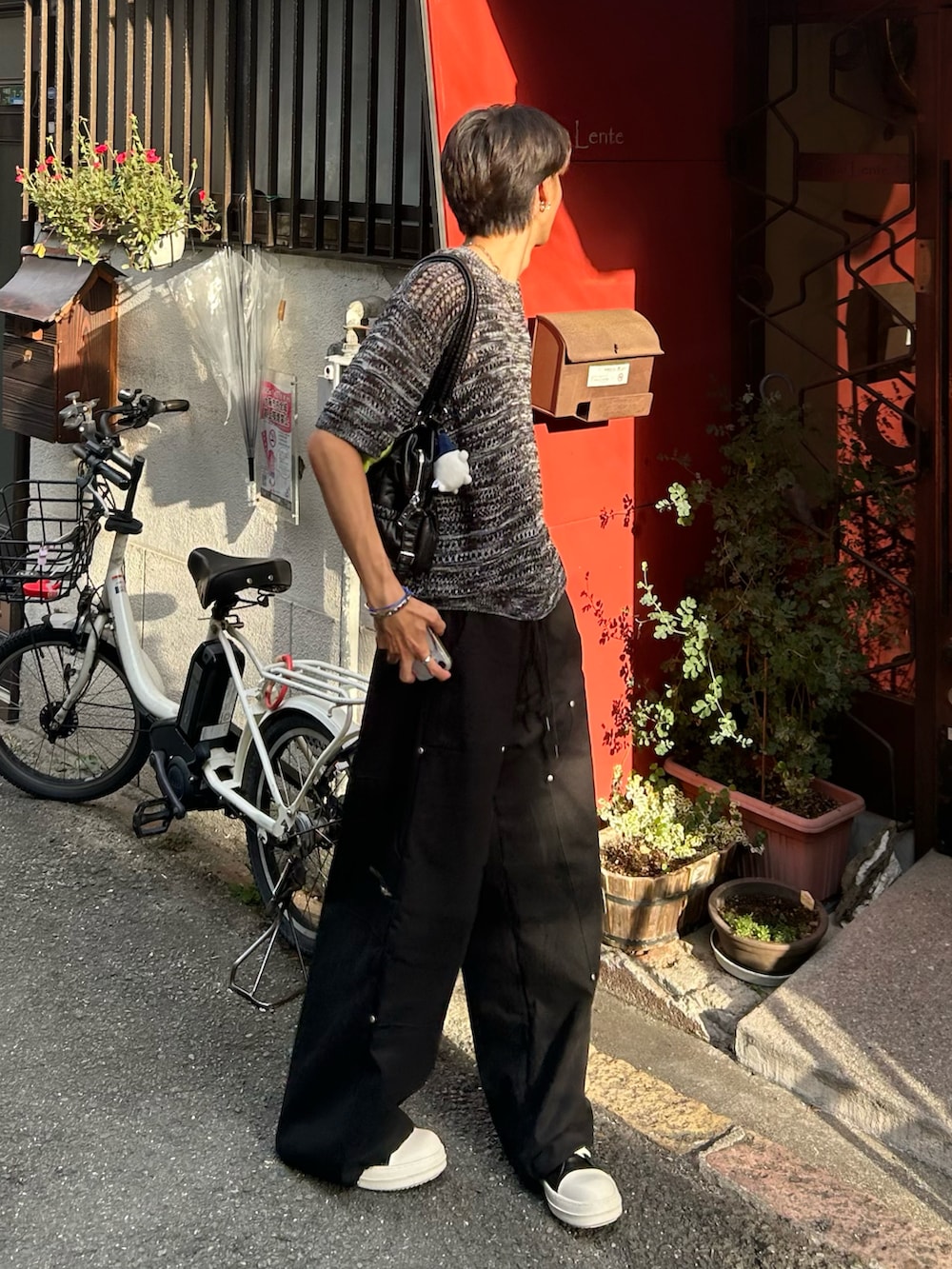 ブラック系のTシャツ/カットソー、ブラック系のトートバッグ、ブラック系のカーゴパンツを着用したメンズの秋コーディネートの2枚目の写真