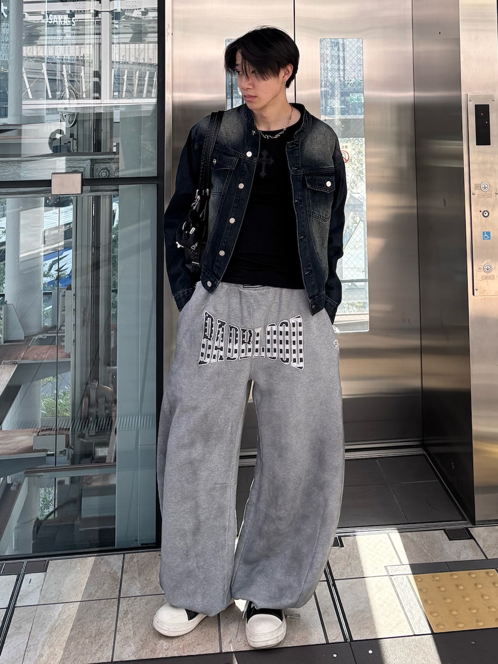 ブルー系のデニムジャケット、その他のTシャツ/カットソー、ブラック系のショルダーバッグを着用したメンズの冬コーディネートの2枚目の写真