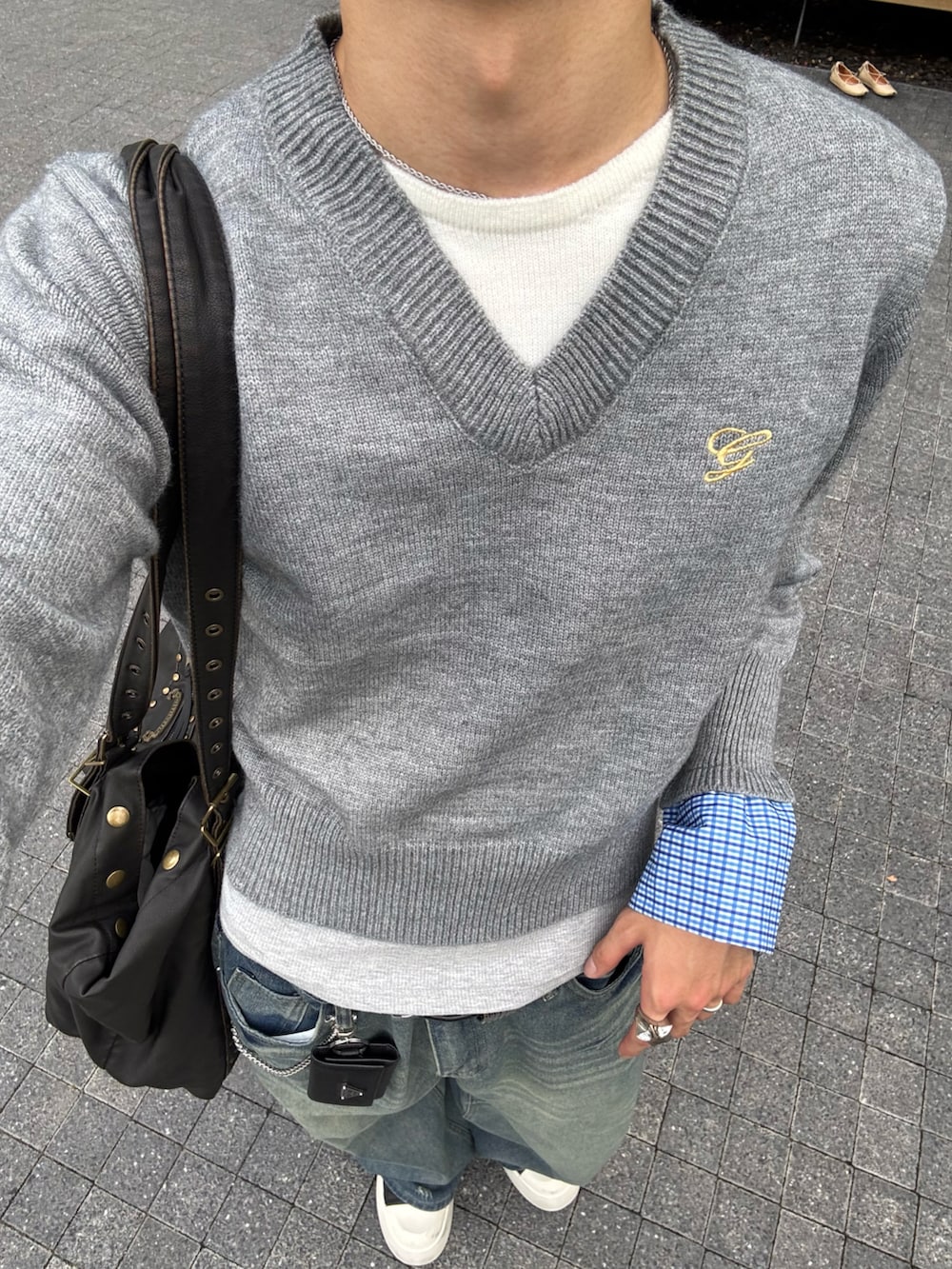 グレー系のニット/セーター、ブルー系のデニムパンツ、ブラック系のスニーカーを着用したメンズの秋コーディネートの5枚目の写真