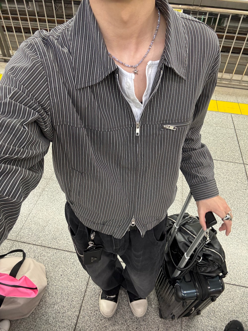 グレー系のブルゾン、ホワイト系のTシャツ/カットソー、ブラック系のデニムパンツを着用したメンズの春コーディネートの4枚目の写真
