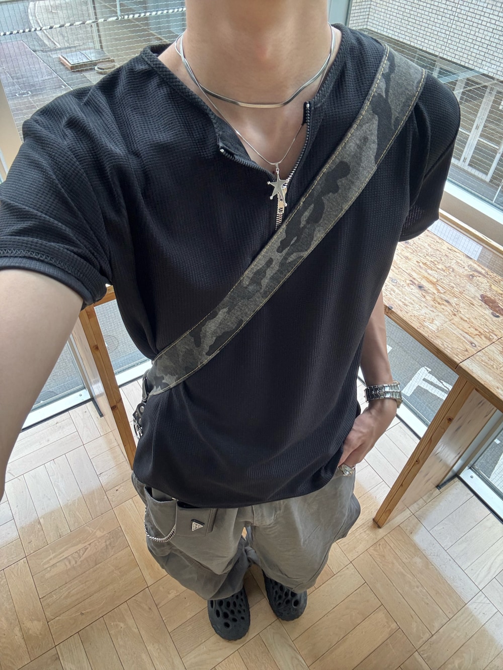 ブラック系のTシャツ/カットソー、グリーン系のショルダーバッグ、グレー系のカーゴパンツを着用したメンズの夏コーディネートの5枚目の写真